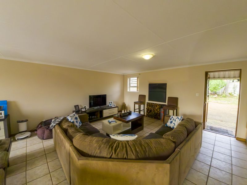 A spacious living room featuring tiled flooring and direct access to the outdoor area, providing a functional and open layout.