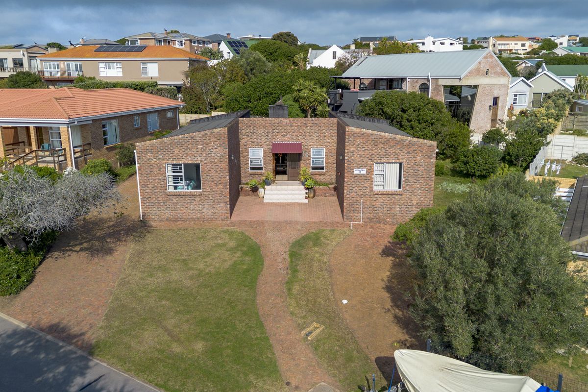 Aerial view of a single-story brick house featuring a paved front walkway, established lawn, and a covered entrance.