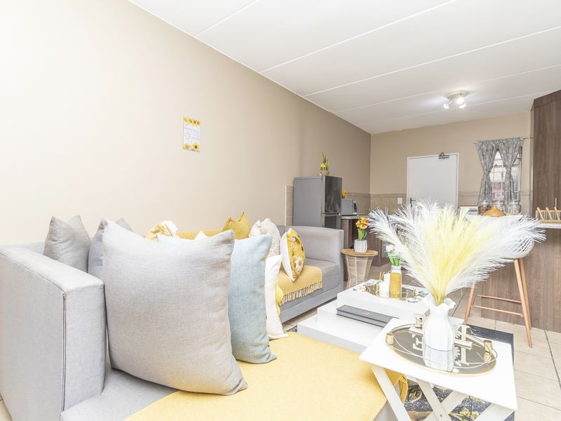 Open-plan living area featuring a kitchen with breakfast bar and tiled flooring, creating a functional and connected space.