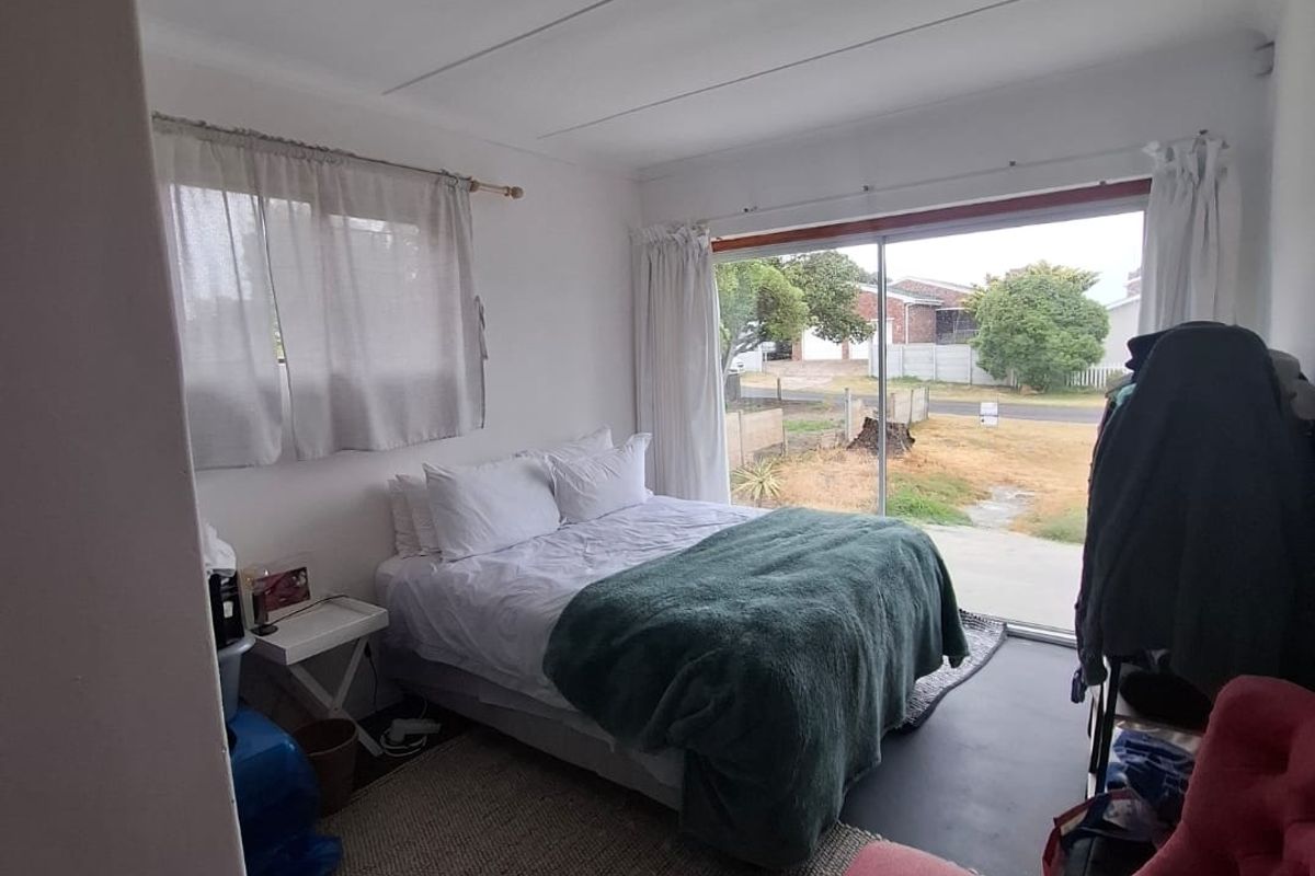 A bedroom featuring a large sliding glass door providing natural light and direct access to the exterior.