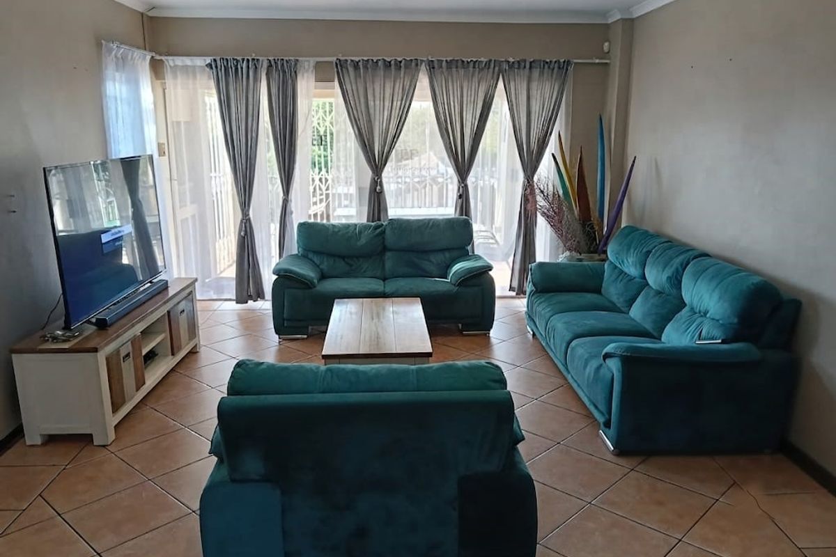 A comfortable living room featuring ceramic floor tiles and large sliding glass doors that provide natural light and access to the outdoor area.