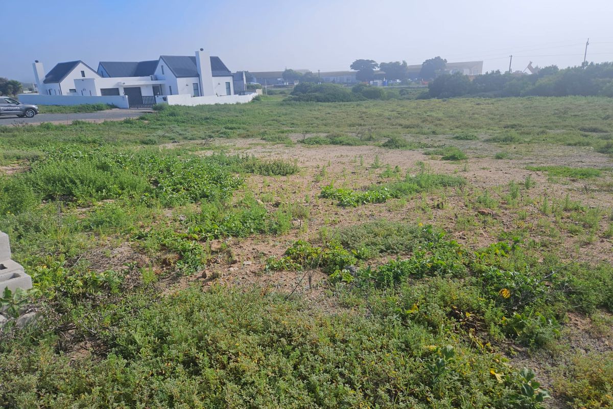 A view of a vacant residential plot of land with natural vegetation, ready for development.