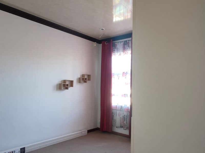 An empty bedroom featuring carpet flooring, a built-in wardrobe, and coving detail, awaiting personal touches to enhance its appeal.