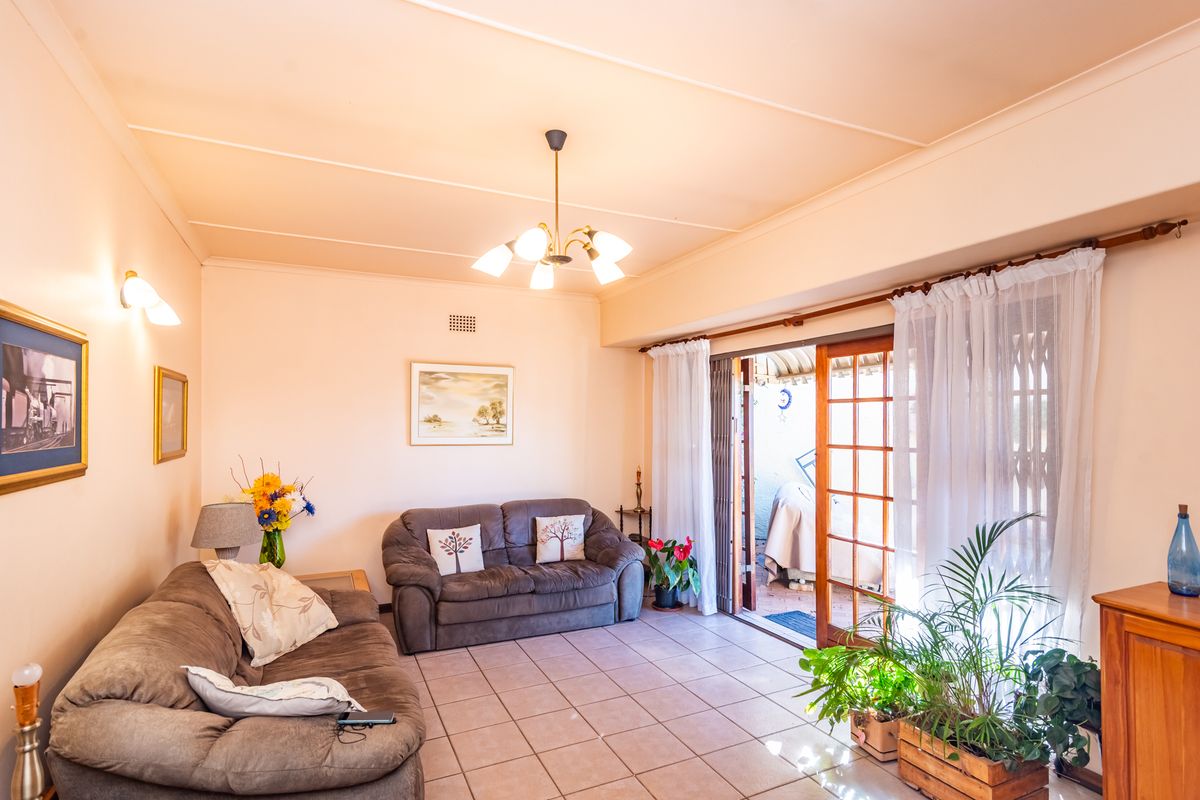 A living room featuring tiled flooring and sliding glass doors that provide access to an outdoor patio area.