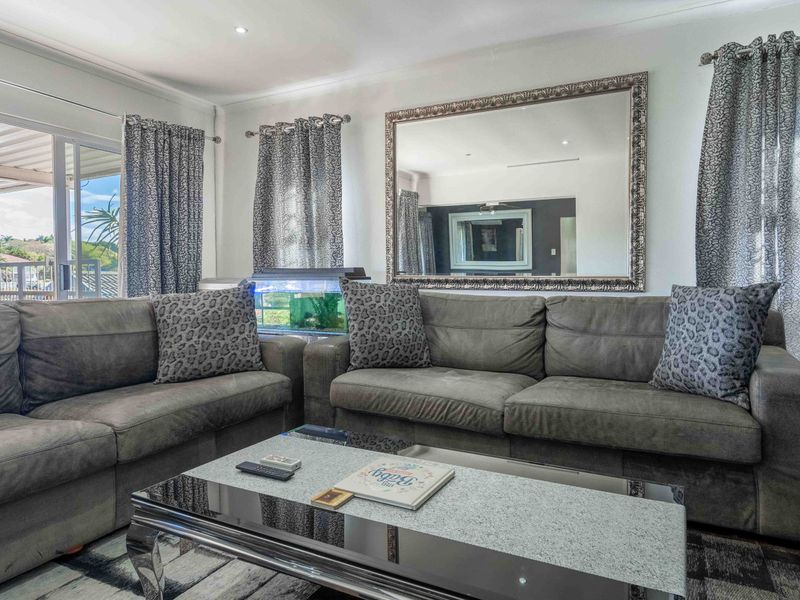 A well-lit living room featuring large sliding glass doors that provide access to an outdoor patio area and ample natural light.