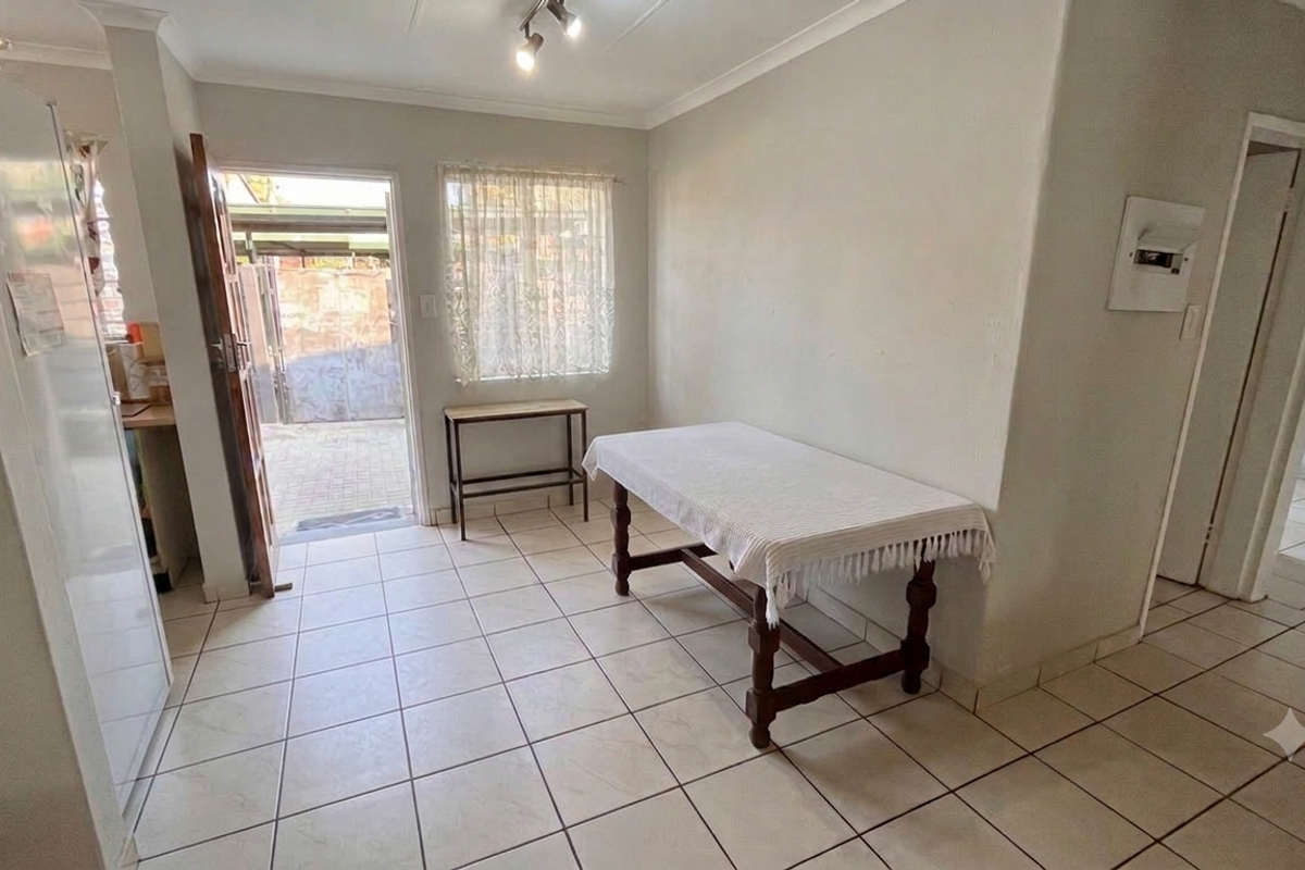A bright living area featuring ceramic floor tiles, cove cornicing, and direct access to an outdoor patio area.