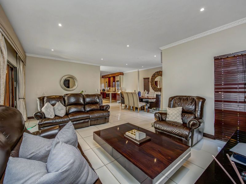 Spacious open-plan living and dining area featuring tiled floors, recessed lighting, and seamless flow into the adjacent kitchen space.