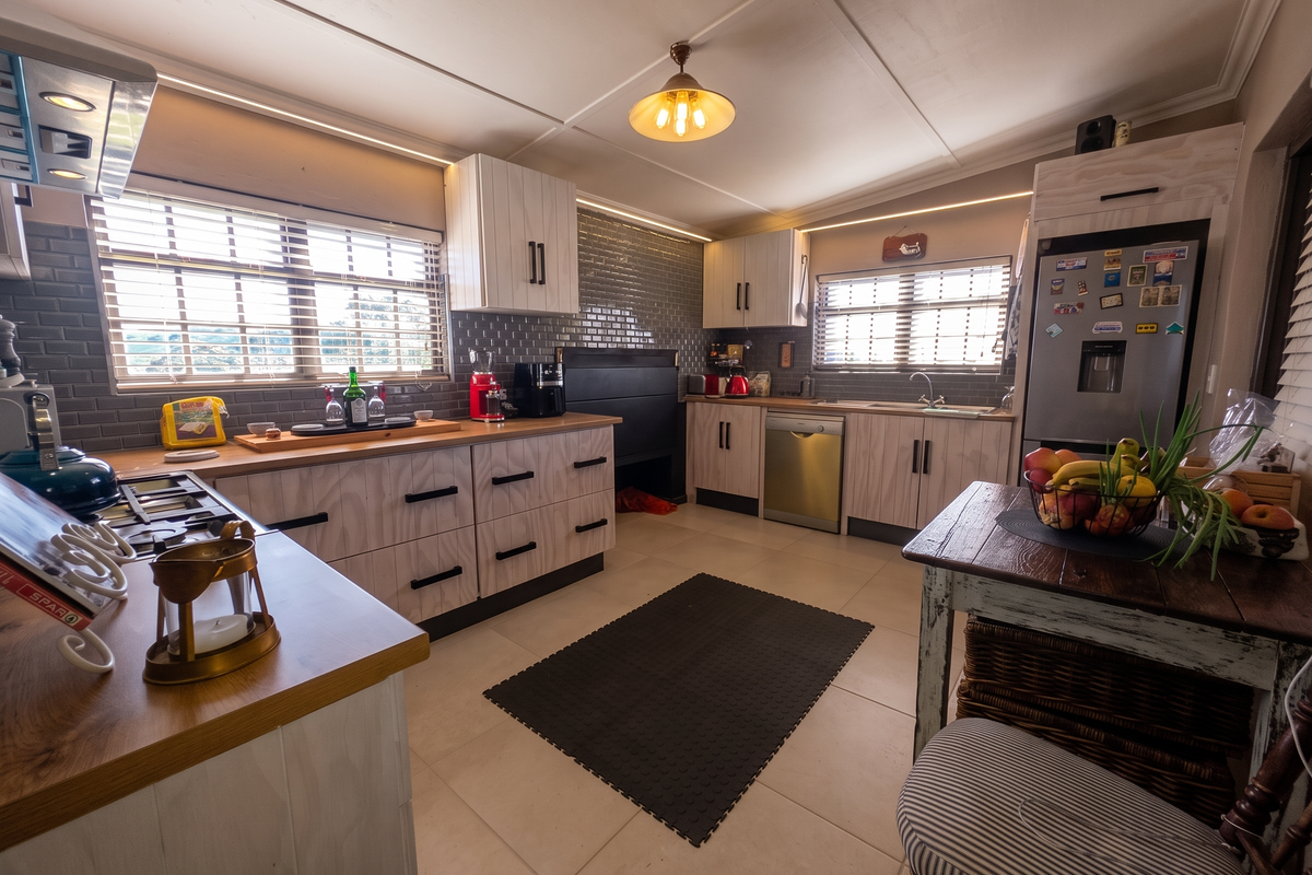 A well-lit kitchen featuring modern cabinetry, a tiled backsplash, integrated appliances, and a functional layout with ample counter space.