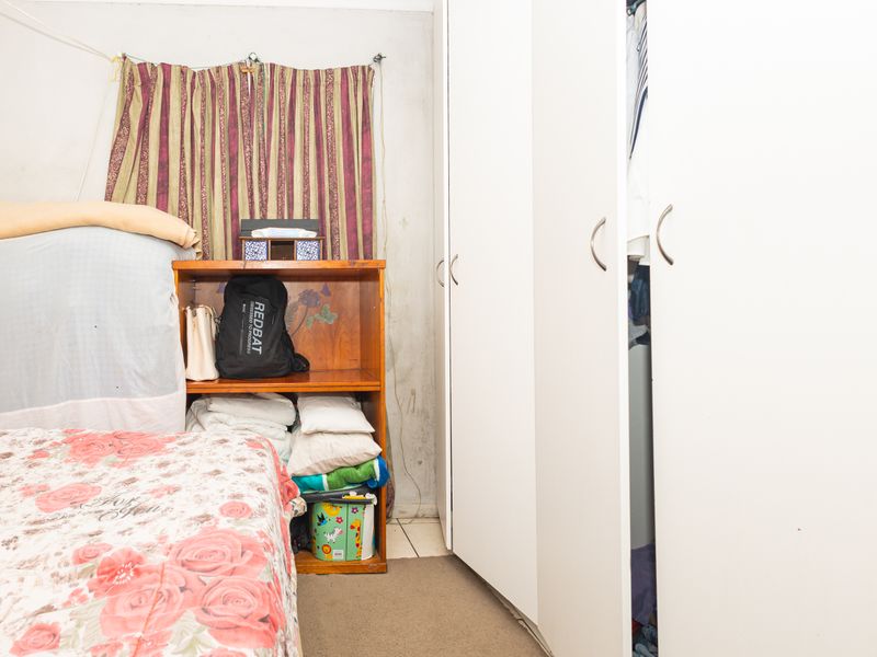 A bedroom featuring built-in cupboards with visible wall wear and staining, requiring cosmetic updates to improve the overall aesthetic.