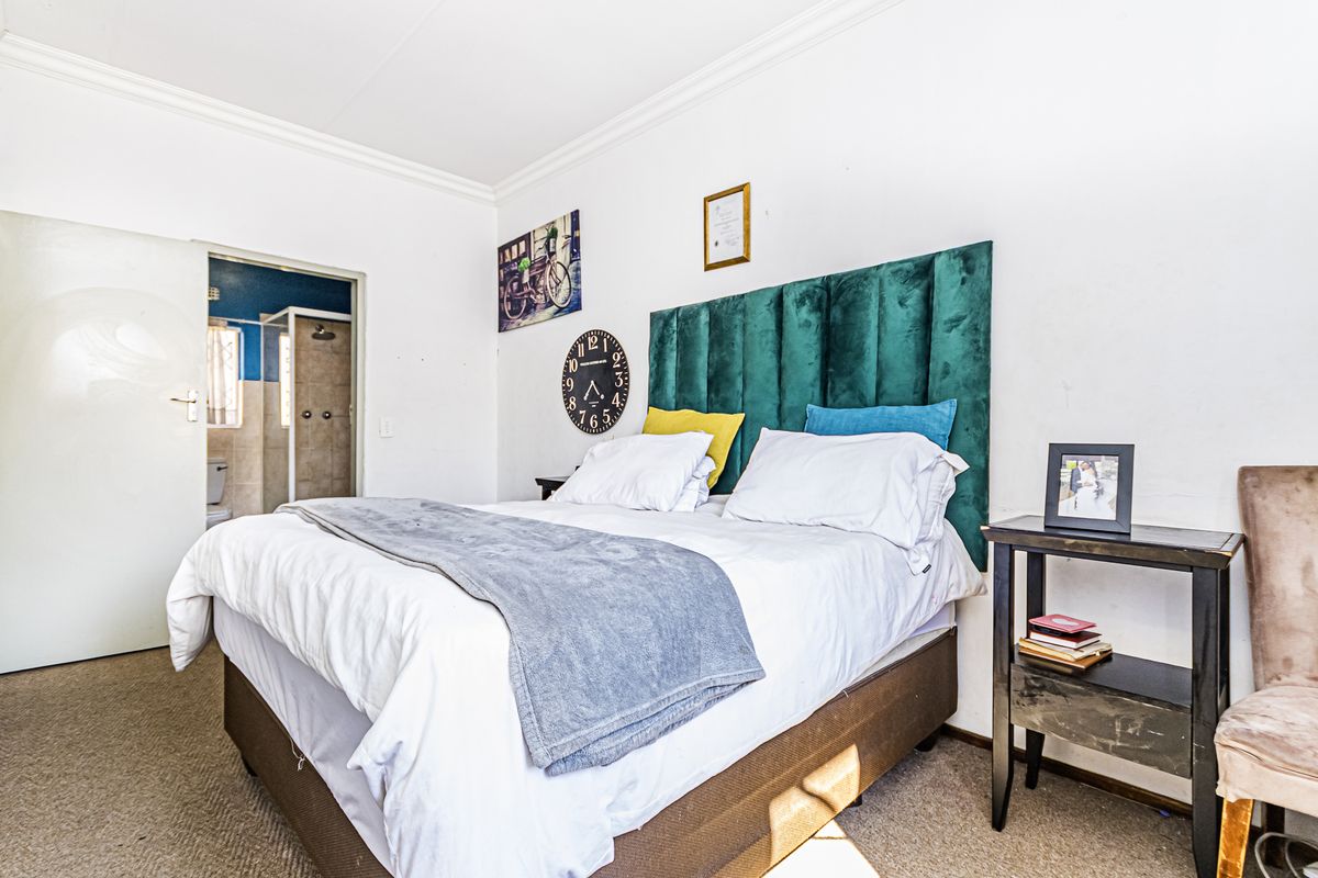 A bedroom featuring carpeted flooring, coved ceilings, and direct access to an en-suite bathroom.