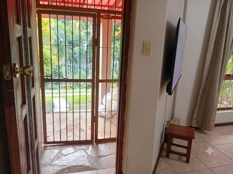 Entryway featuring stone flooring and a security gate leading to an outdoor area, providing a functional transition space for the home.