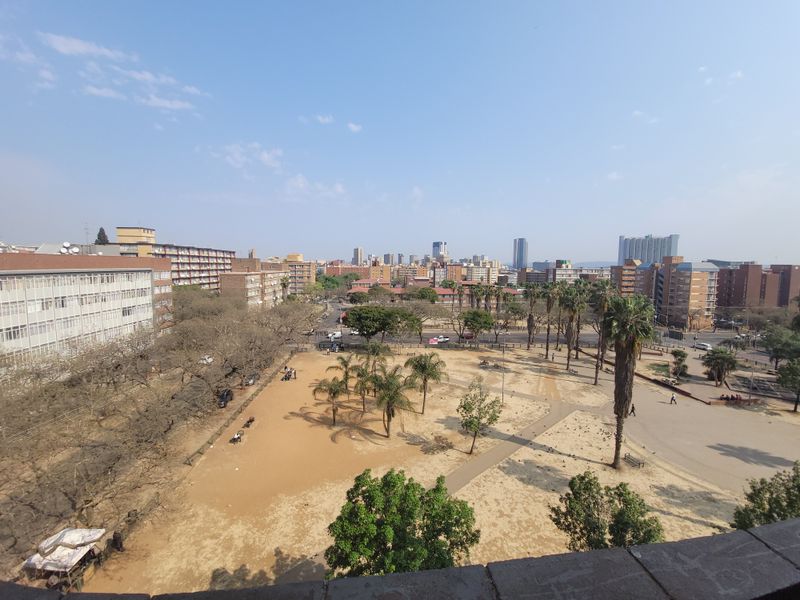An elevated urban view overlooking a public park area surrounded by residential apartment buildings and city infrastructure.