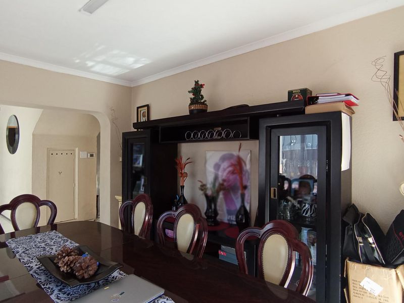 A dining room featuring tiled flooring and an arched doorway leading to an adjacent living space.