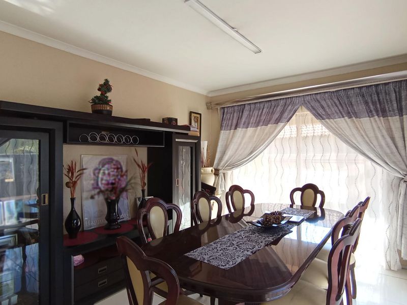 A dining room featuring tiled flooring and window treatments, providing a functional space for family meals and entertaining.