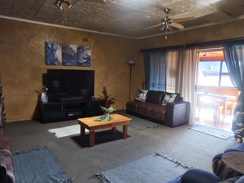 Spacious living room featuring a stone accent wall, textured ceiling, and direct access to an outdoor patio area through sliding glass doors.