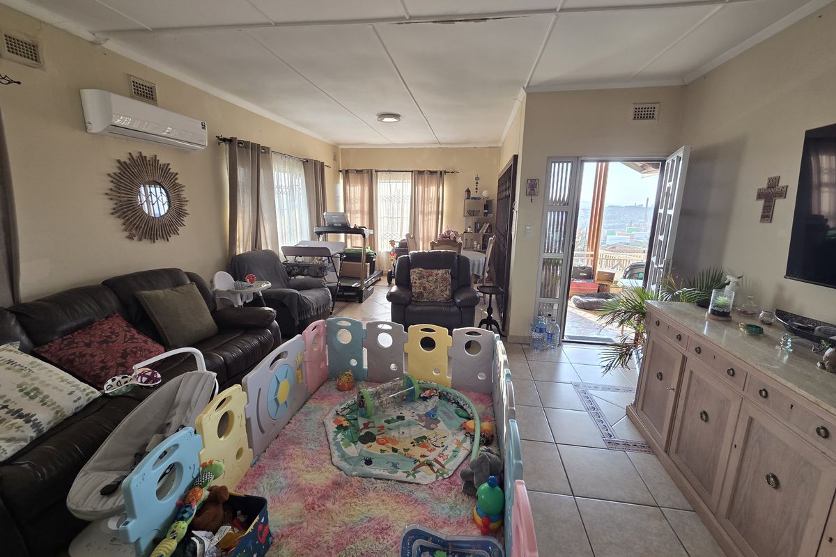 Spacious living room featuring tiled flooring, a wall-mounted air conditioner, and direct access to an outdoor patio area.