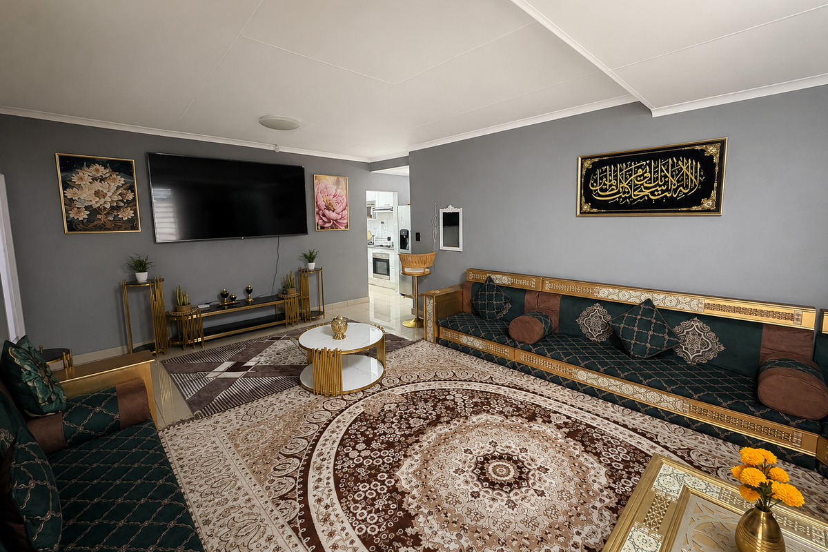 A well-maintained living room featuring neutral grey walls, tiled flooring, and decorative coving, with an open transition to the kitchen area.