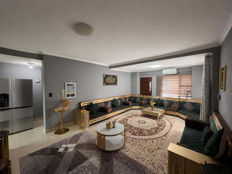 An open-plan living area featuring tiled flooring, a split-system air conditioner, and neutral grey wall finishes, providing a versatile space for relaxation.