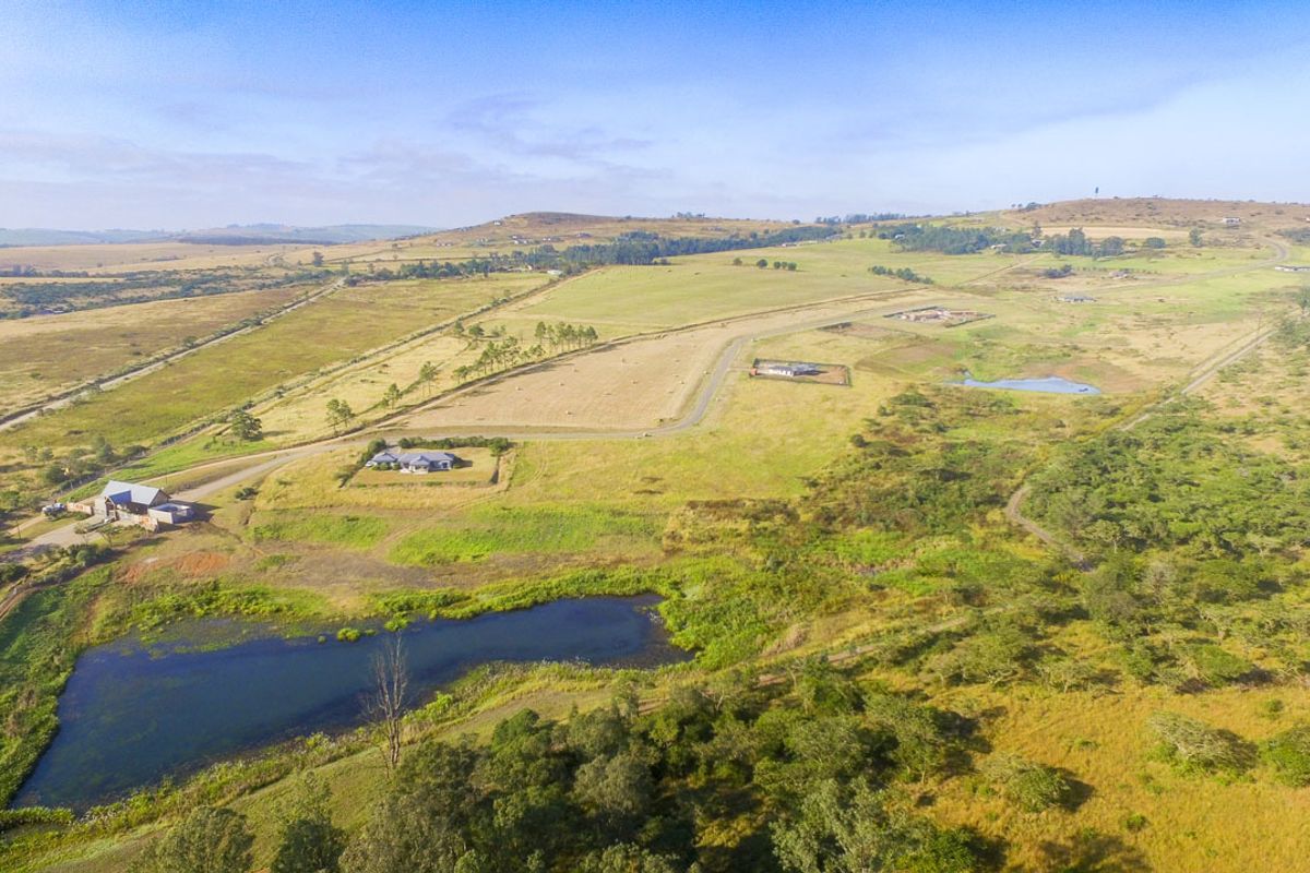 An aerial view of a residential estate featuring open land, natural ponds, and established access roads within a scenic rural landscape.