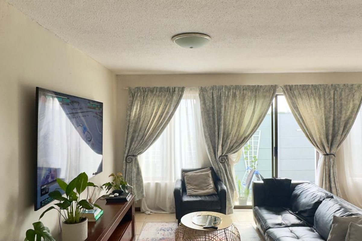 A comfortable living room featuring a textured popcorn ceiling, flush mount lighting, and a large sliding glass door providing access to the outdoor area.
