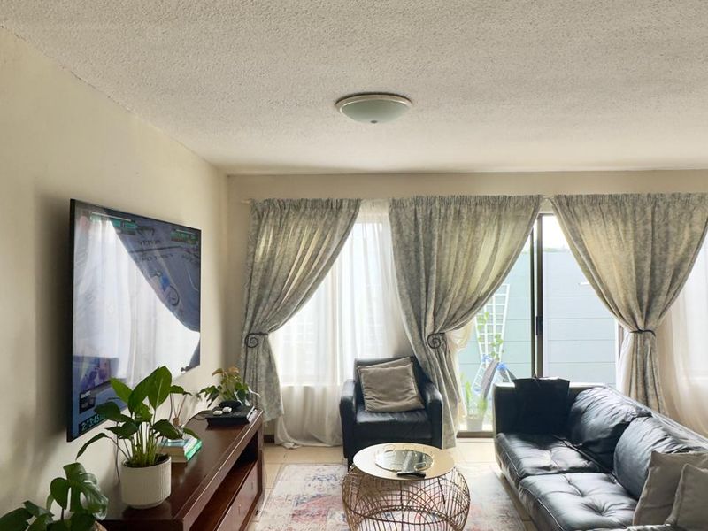 A comfortable living room featuring a textured popcorn ceiling, flush mount lighting, and a large sliding glass door providing access to the outdoor area.