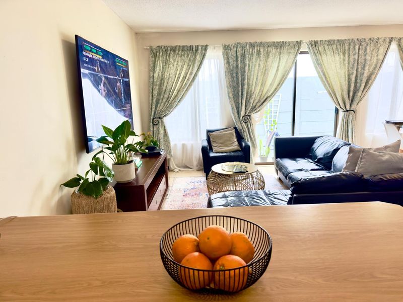 Open plan living area featuring tiled flooring and a sliding glass door providing access to the outdoor space.