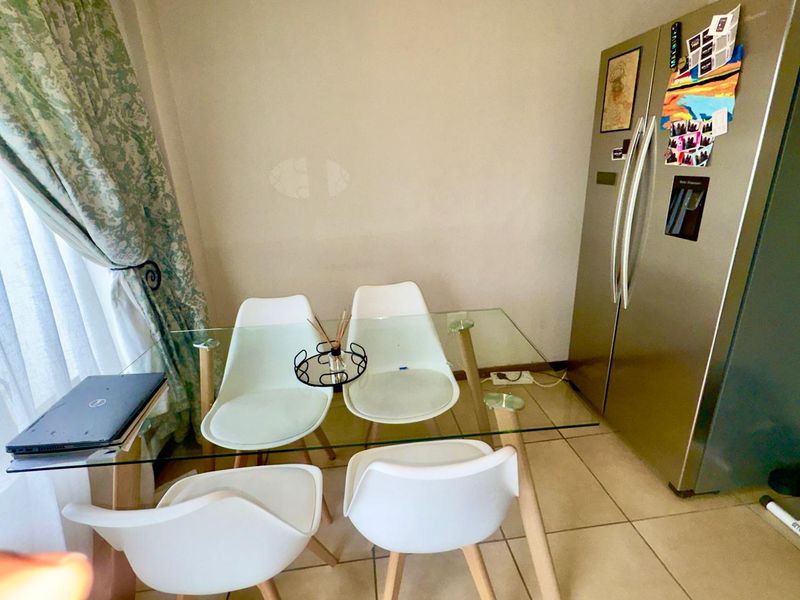 A compact dining area featuring tiled flooring, suitable for a small table and chairs setup.