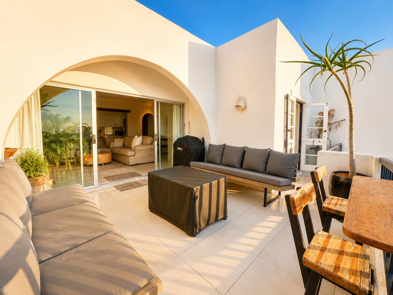 A spacious, well-maintained balcony featuring tiled flooring, an elegant arched architectural design, and seamless access to the interior living area through sliding glass doors.
