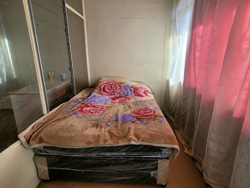 A bedroom featuring built-in cupboards with sliding glass doors and natural light from the window.