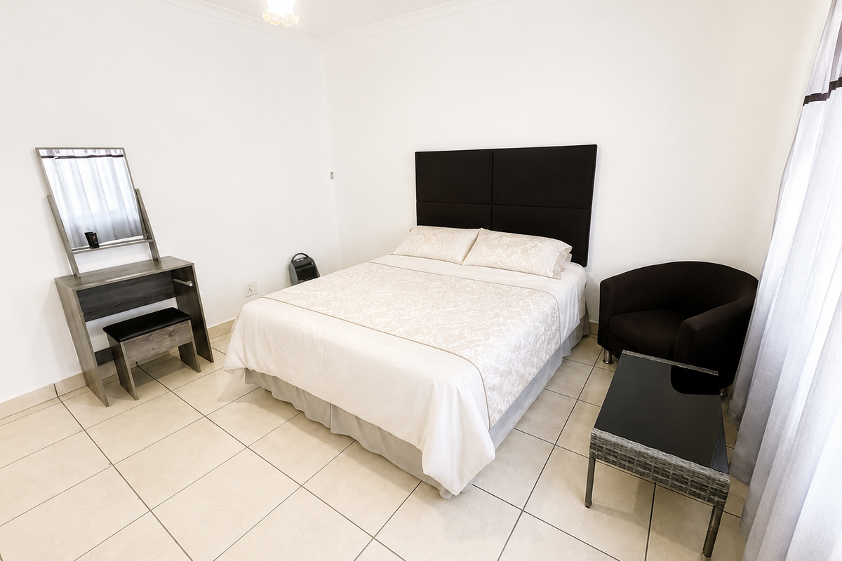 A well-maintained bedroom featuring neutral tiled flooring and clean white walls, providing a bright and functional living space.