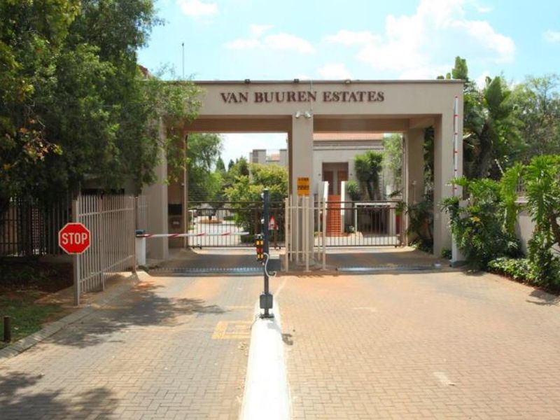 Main entrance gate and security access point for Van Buuren Estates, featuring a paved driveway and controlled boom gate access.