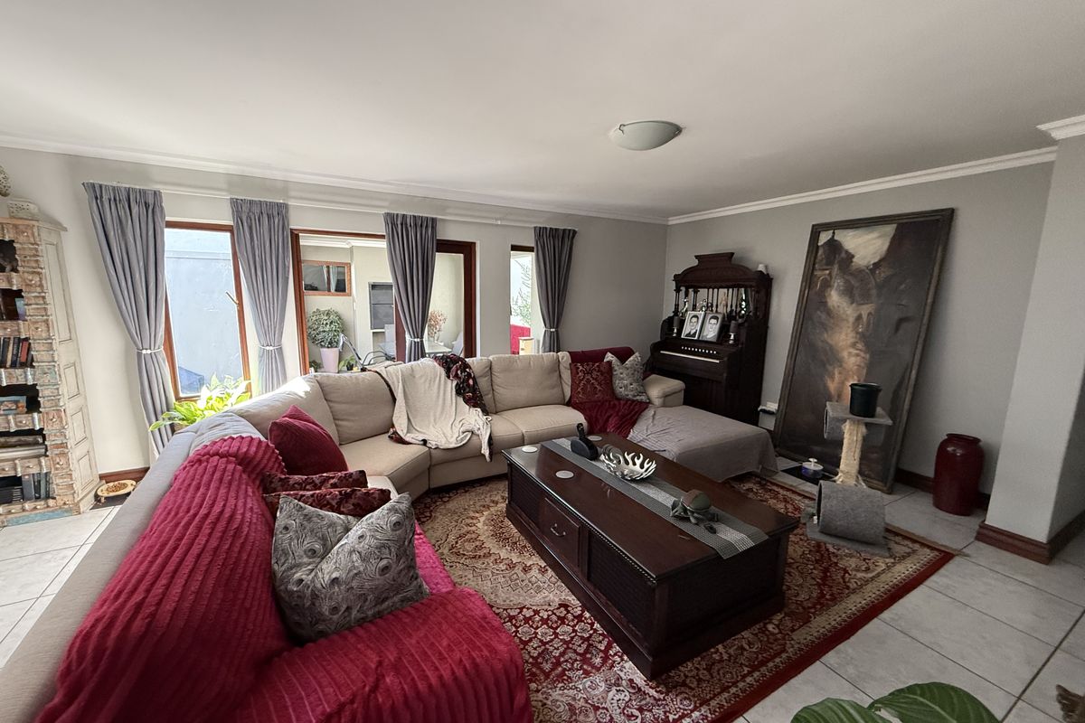 Spacious living room featuring tiled flooring and large sliding glass doors that provide natural light and access to the outdoor area.