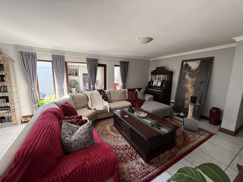 Spacious living room featuring tiled flooring and large sliding glass doors that provide natural light and access to the outdoor area.