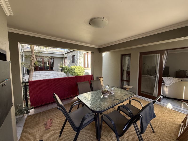 A covered patio area featuring a built-in fireplace, tiled flooring, and direct access to the interior through sliding glass doors.