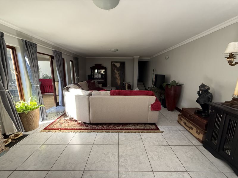 Spacious living room featuring neutral tiled flooring and large sliding glass doors that provide direct access to the outdoor patio area.