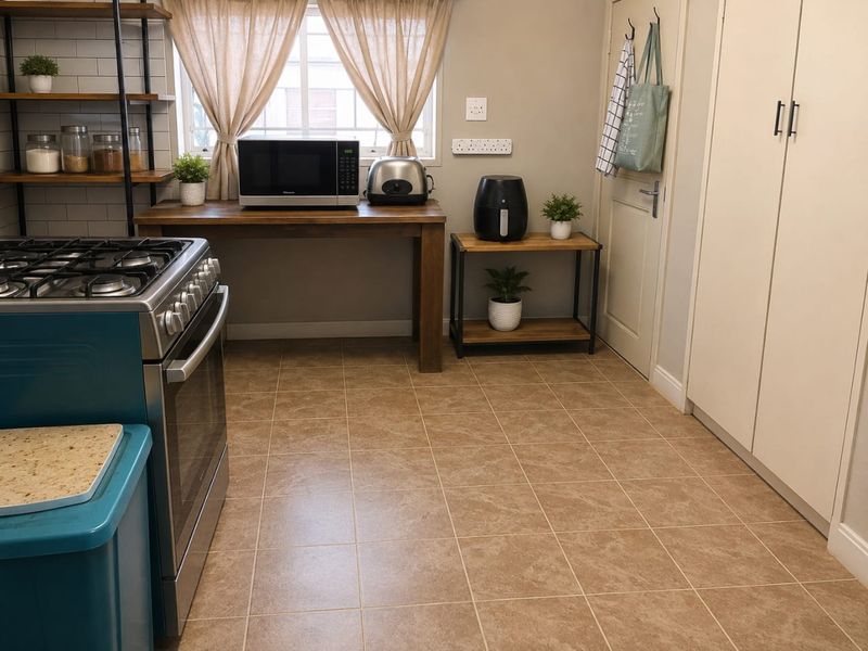 A functional kitchen featuring a gas stove, subway tile backsplash, open shelving, and ample built-in cabinetry with neutral tiled flooring.