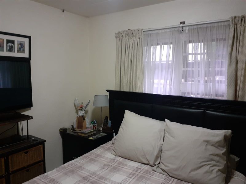 A standard bedroom featuring neutral wall finishes and window treatments, providing a functional space for rest.