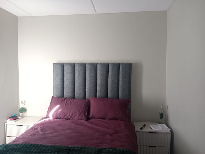 A well-lit bedroom featuring neutral wall tones and a clean, minimalist aesthetic.