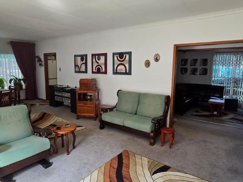Open plan living and dining area featuring carpeted flooring and access to an adjacent room through a wide doorway.