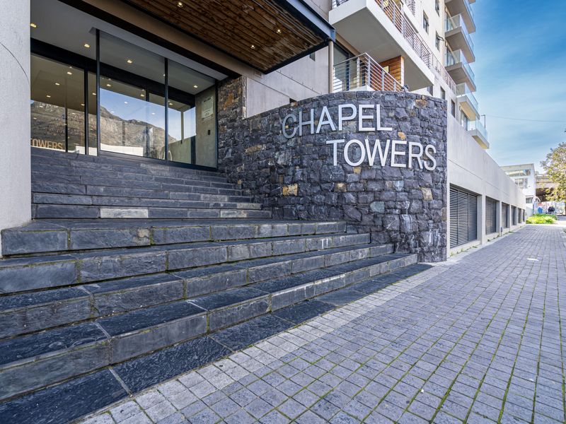 The main entrance of Chapel Towers featuring stone-clad facade, grand stone steps, and modern glass entry doors.