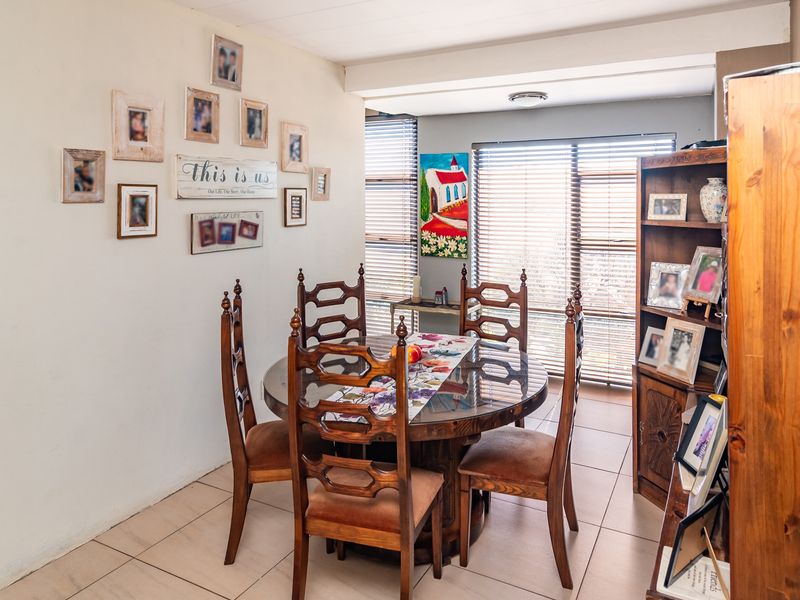 A dining room featuring tiled flooring and venetian blinds, providing a functional space for meals.