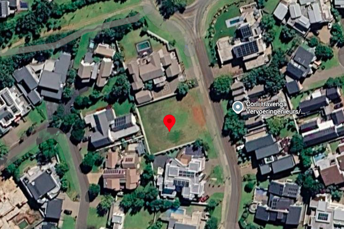 Aerial view of a vacant residential plot situated within an established suburban neighborhood.