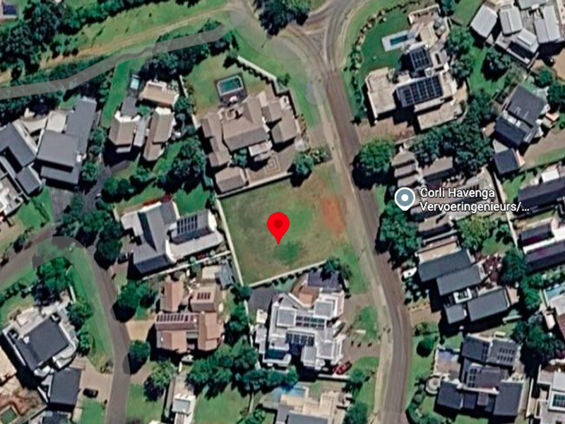 Aerial view of a vacant residential plot situated within an established suburban neighborhood.