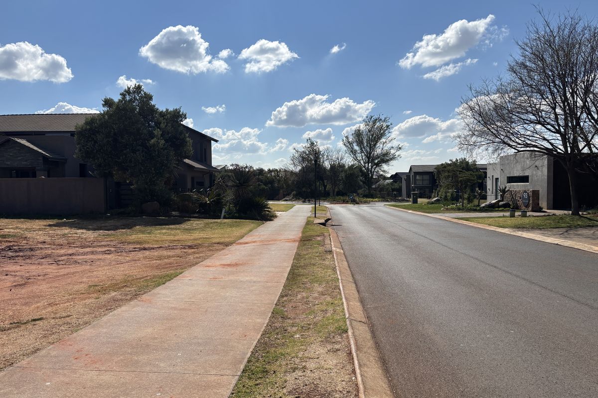 A clear street view showing the paved sidewalk and asphalt road in a residential estate setting.