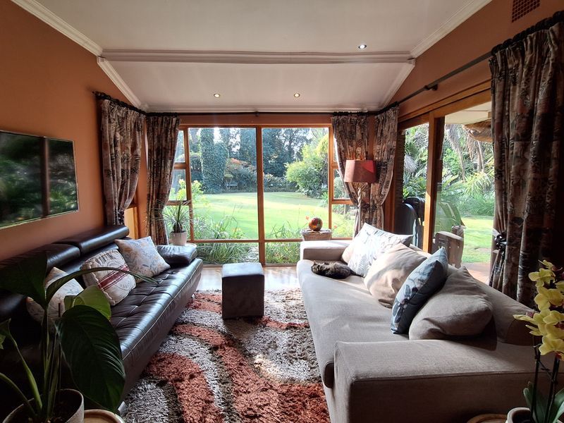 A cozy living room featuring large glass sliding doors that provide abundant natural light and views of the lush garden.
