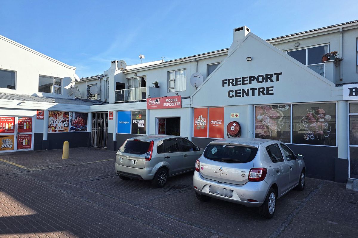 Front exterior view of the Freeport Centre, featuring a paved parking area and commercial storefront signage.
