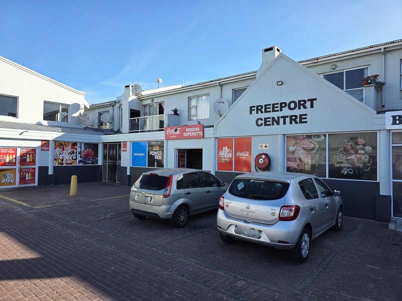 Front exterior view of the Freeport Centre, featuring a paved parking area and commercial storefront signage.