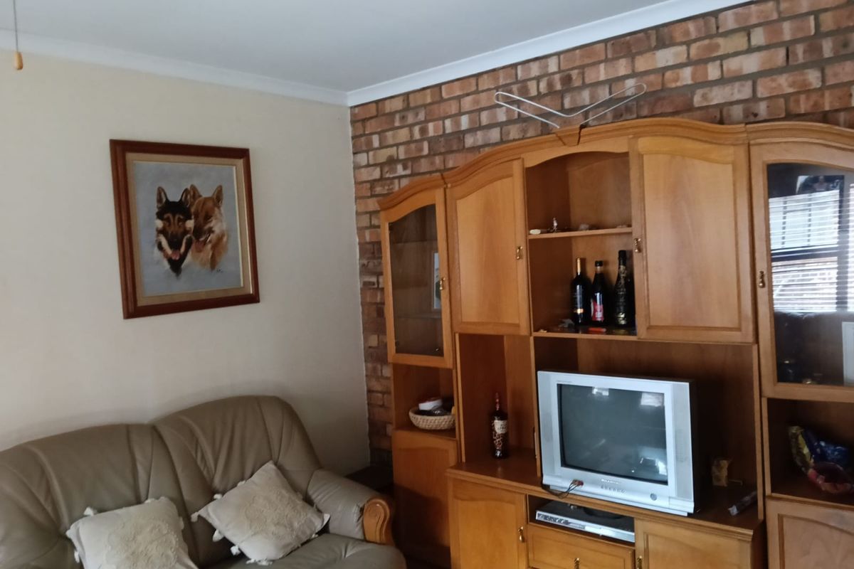 A living room featuring an exposed brick feature wall and classic coving, offering a traditional aesthetic ready for modern updates.