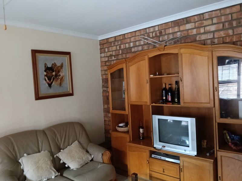 A living room featuring an exposed brick feature wall and classic coving, offering a traditional aesthetic ready for modern updates.