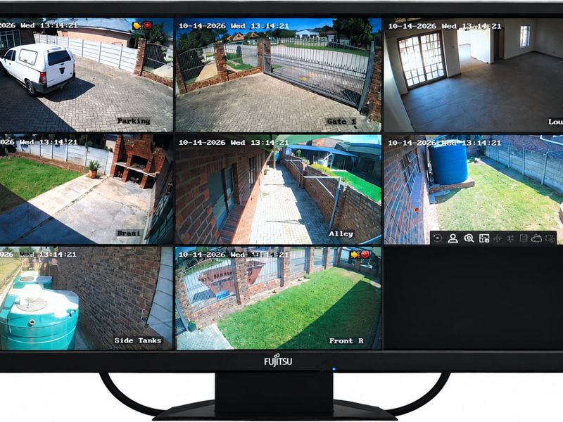 A monitor displaying a multi-view security camera feed showing various exterior areas of a residential property.